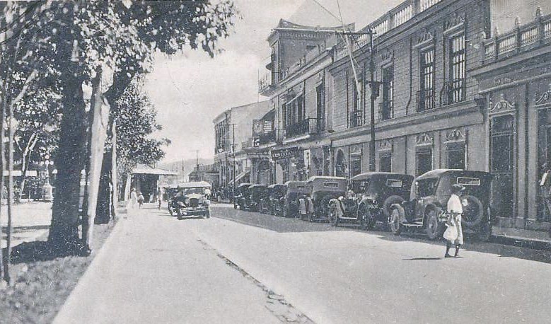 Vehículos estacionados enfrente de la fachada del Banco Occidenta, en la década de 1920. Ese predio corresponde en la actualidad al edificio BINAES.